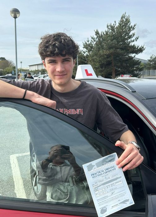 Young driver leaning on the car with an Ipswich driving test pass certificate