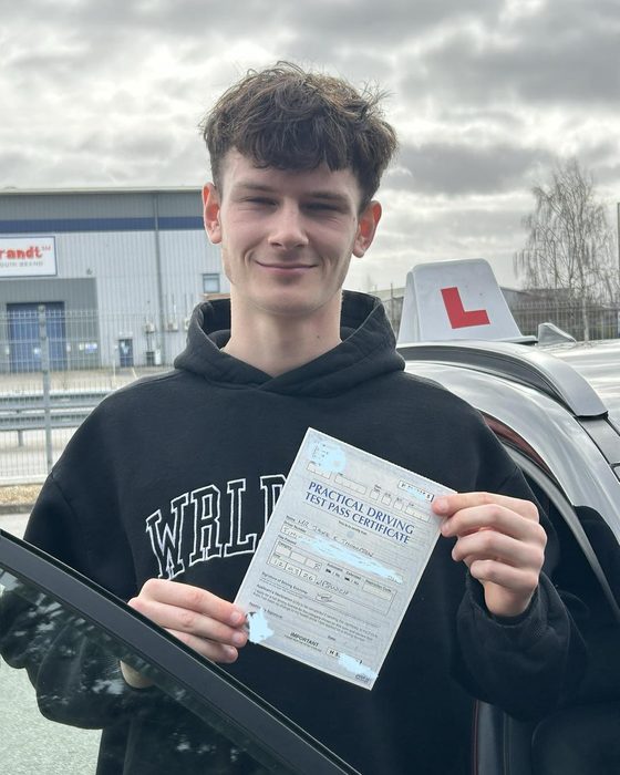 Learner driver with a driving test pass certificate beside a Hallwood Training Services car in Ipswich
