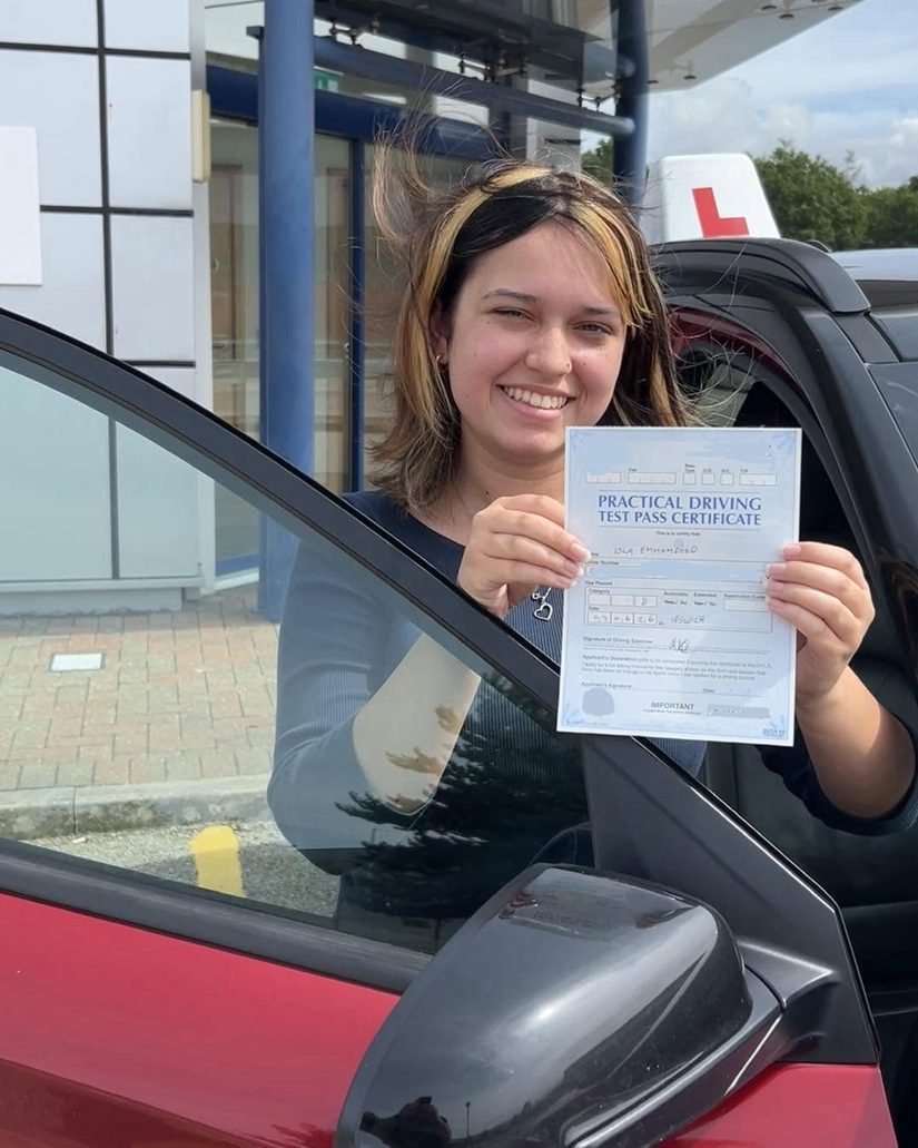Pupil smiling with her practical driving test pass certificate outside the Ipswich driving test centre, where Felixstowe learners take their test
