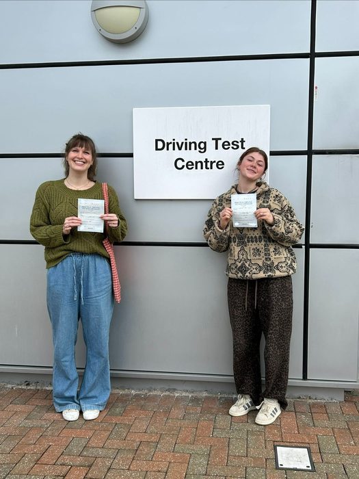 Two learner drivers with driving test pass certificates at Ipswich driving test centre